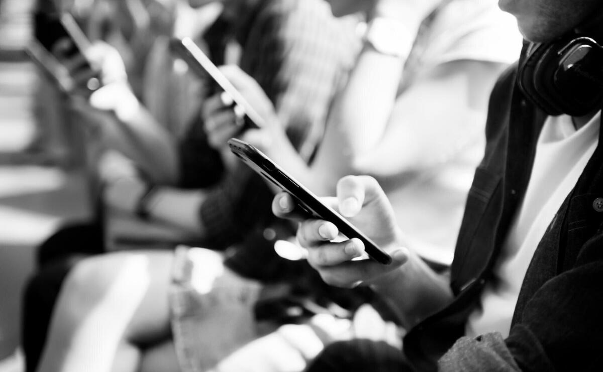 Group of young adult friends using smartphones in the subway