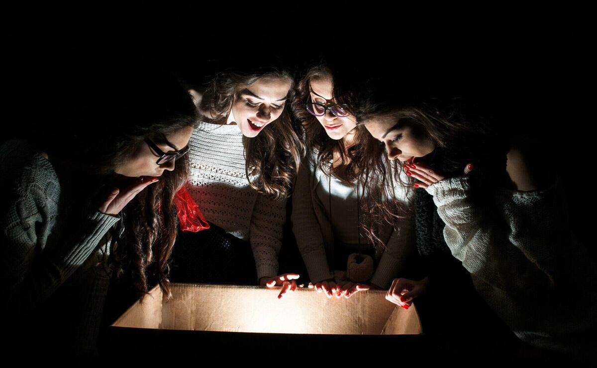 Astonished friends looking inside a box