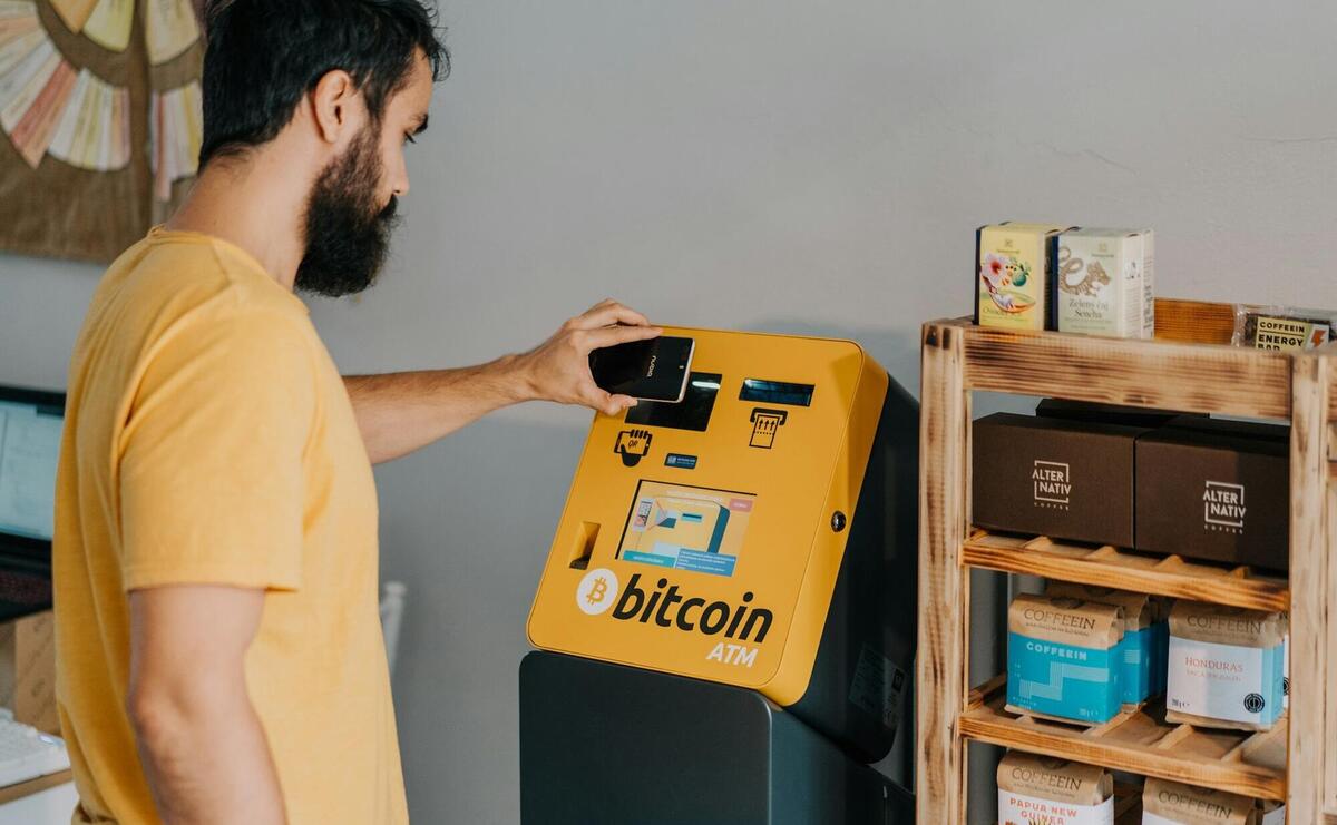 a man putting a bitcoin machine into a bin