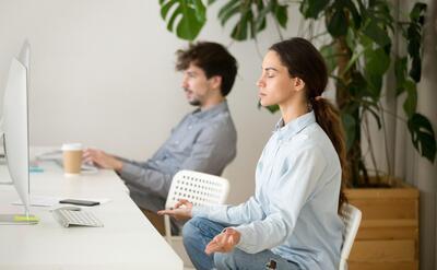 Mindful calm young woman taking break in office for meditation