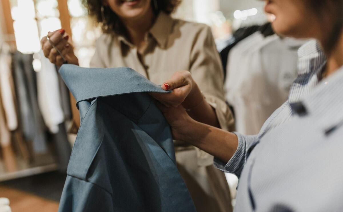 Customer Looking at a Blue Blouse in a Boutique