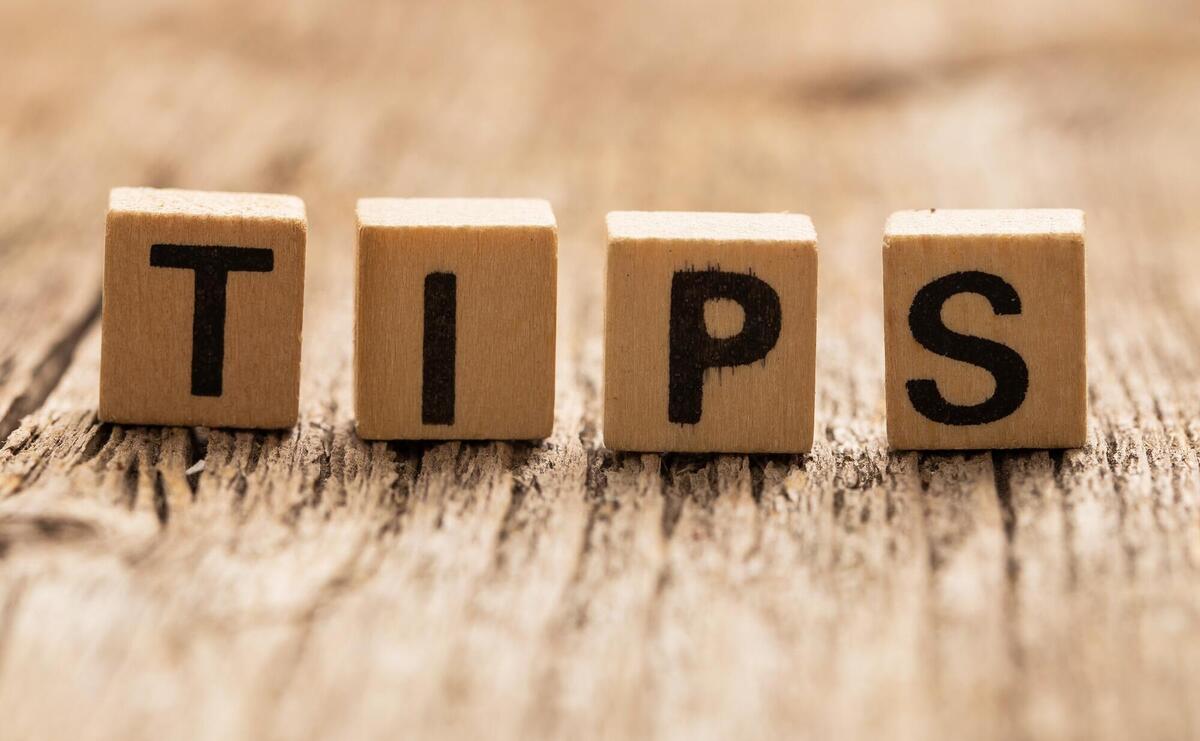 Wooden blocks spelling "TIPS" on a rustic textured background.