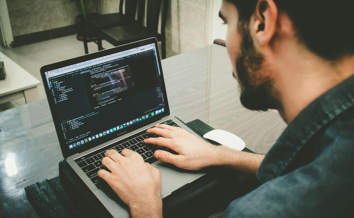 man programming using laptop