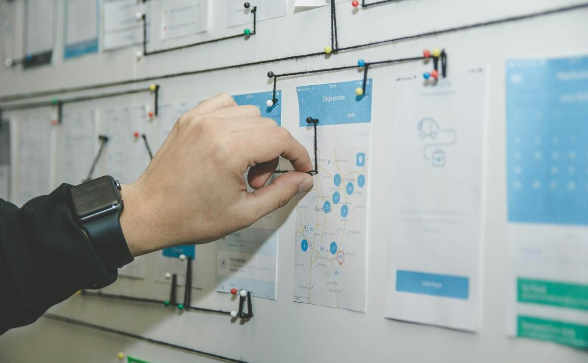 person working on blue and white paper on board